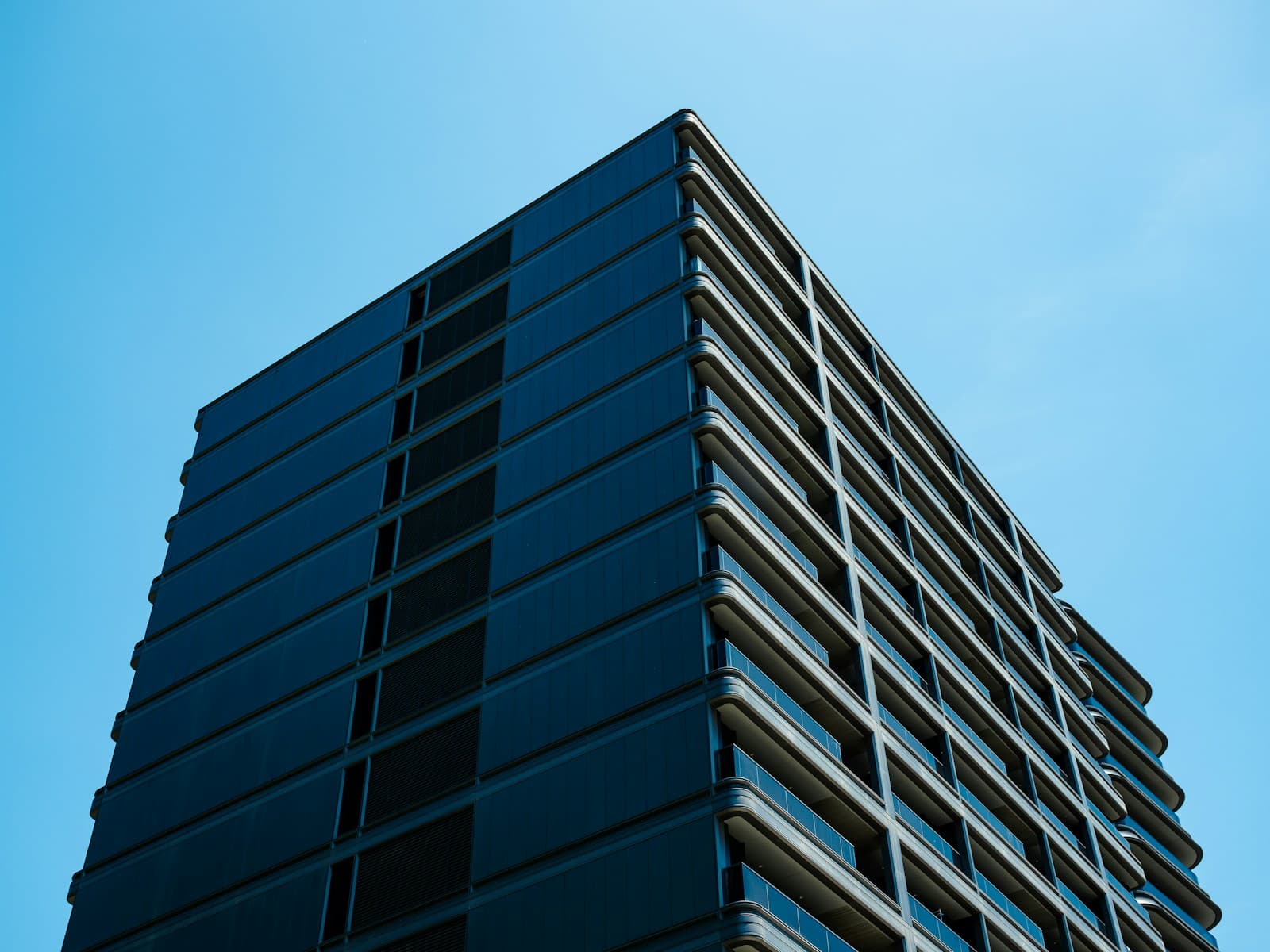 A modern glass building against a clear blue sky